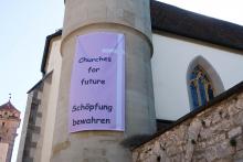 Plakat an Kirchturm: Churches for future - Schöpfung bewahren