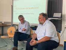 Gespräch zwischen M. Fritz und M. Bauer vor Präsentation mit Überschrift „Humanismus als Konfession?“